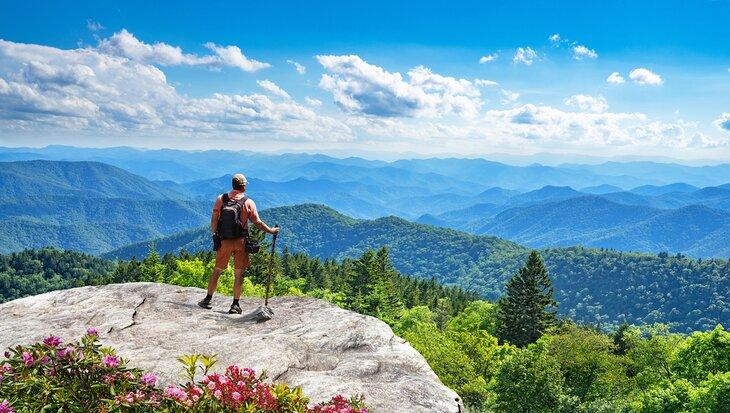 Un excursionista disfrutando de la vista sobre las Montañas Humeantes desde el Blue Ridge Parkway en Carolina del Norte