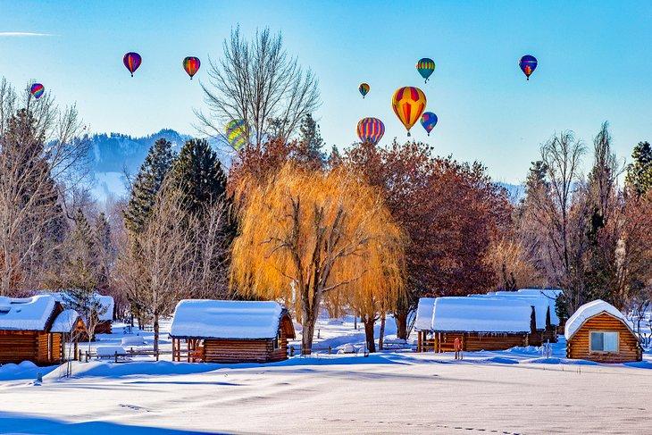 Globos de aire caliente sobre cabañas cubiertas de nieve en Winthrop