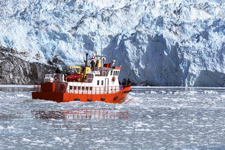 Un barco turístico tomando fotos de un iceberg