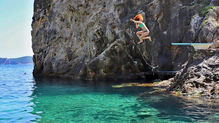 Saltando desde la plataforma de buceo en La Grotta Beach