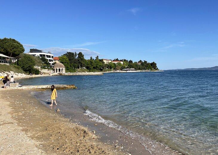 Una mujer en la playa de Kolovare