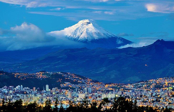 Quito bei Sonnenaufgang mit dem Cotopaxi-Vulkan in der Ferne