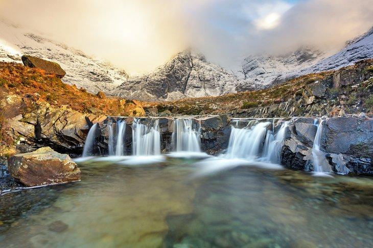 Las Piscinas de Hadas en la Isla de Skye respaldadas por las nevadas Montañas de Cuillin