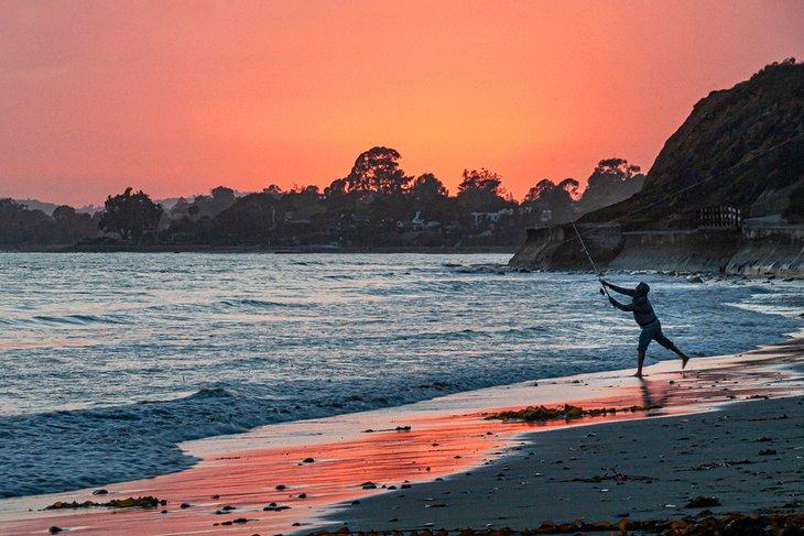 Pescador lanzando desde Playa Summerland al atardecer