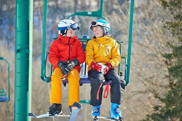 Niños disfrutando del viaje en telesilla en Afton Alps Resort