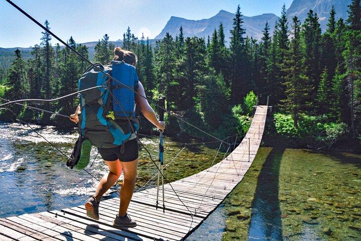 Mochilero en un puente colgante en el Sendero Nacional Escénico del Noroeste del Pacífico en el Parque Nacional de Glacier
