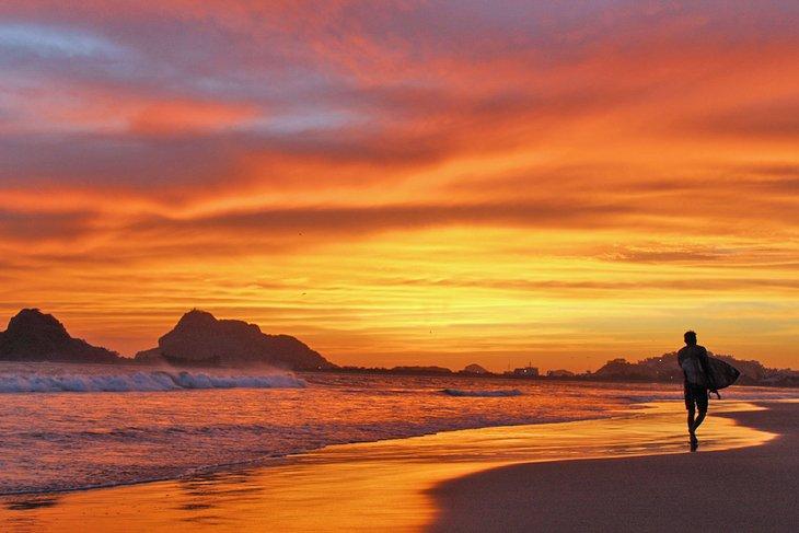 Surfista en la playa al atardecer en Mazatlán