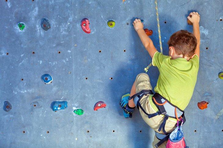 Joven escalador en la pared de escalada