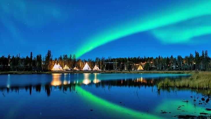 Les aurores boréales au-dessus des tipis à Yellowknife, Territoires du Nord-Ouest