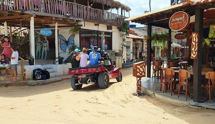 Tres personas en la parte trasera de un buggy de playa
