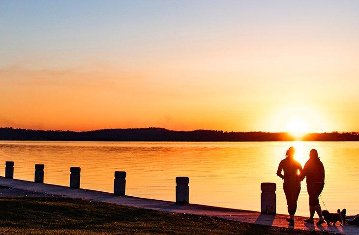 Paar, das bei Sonnenuntergang auf einem Weg entlang des Lake Monona spaziert