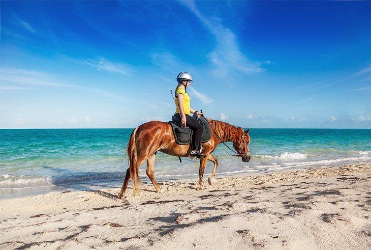 Mädchen reitet am Long Bay Beach