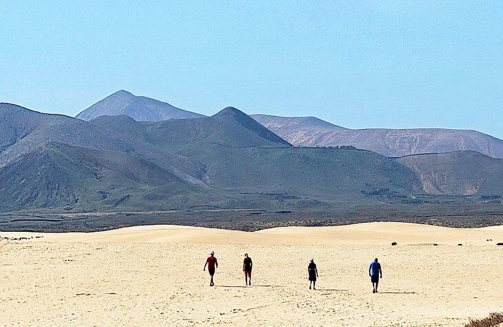 Personas caminando en las dunas del Parque Natural Corralejo
