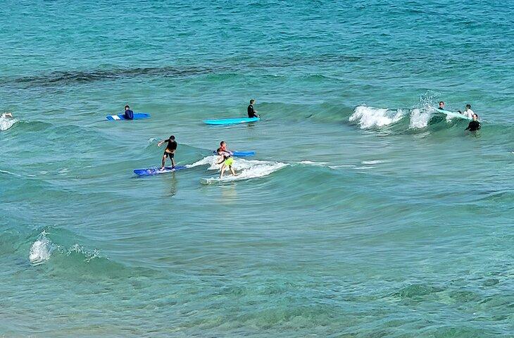 Niños surfeando en una playa del Parque Natural Corralejo
