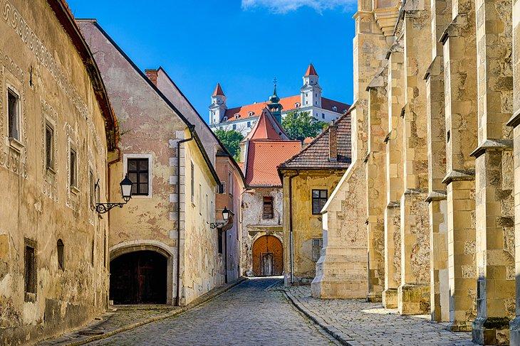 Rue dans la vieille ville de Bratislava avec le château de Bratislava au loin