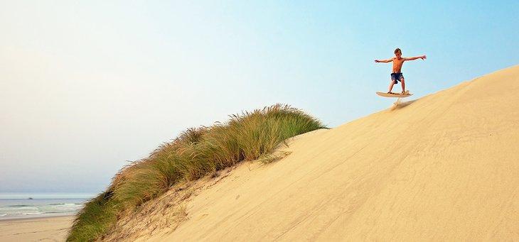 Sandboarding en el Área Recreativa Nacional de las Dunas de Oregón cerca de Florencia, Oregón