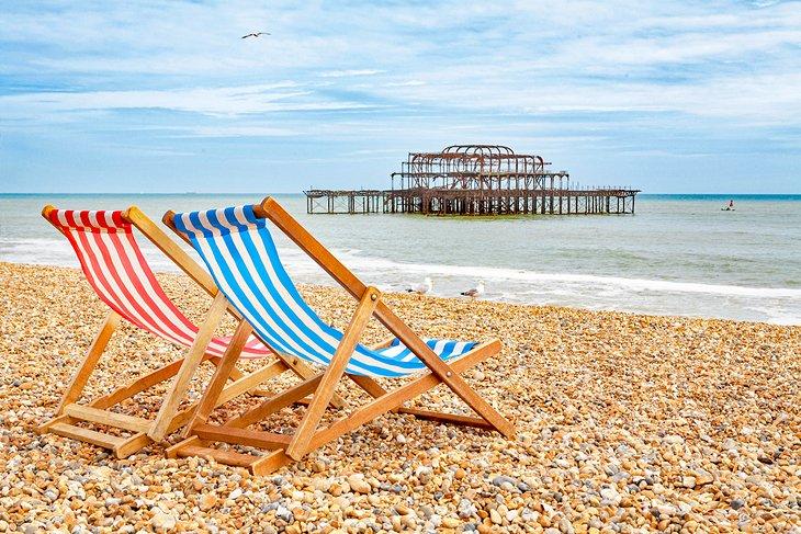 Sillas de playa en la Playa de Brighton con el West Pier al fondo