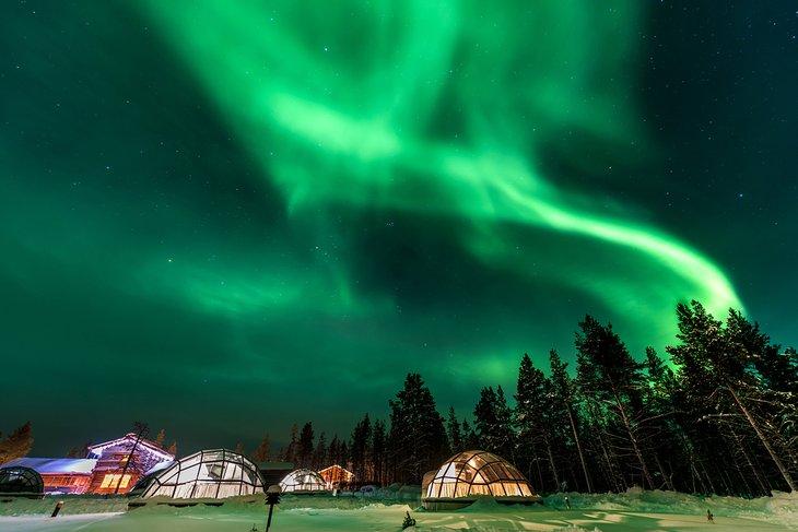 Luces del norte sobre casas iglú en Laponia, Finlandia