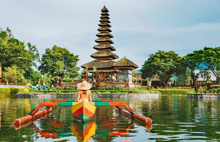 Eine Frau in einem Outrigger vor Pura Ulun Danu Bratan