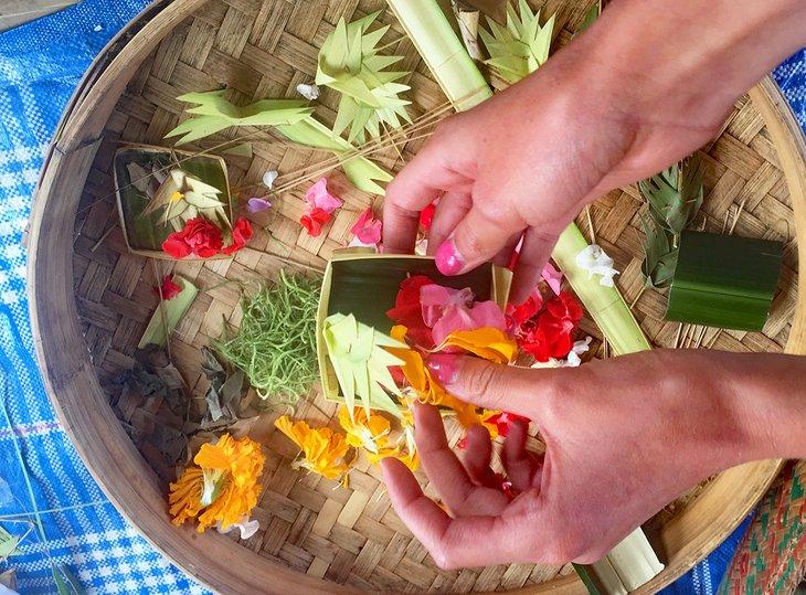 Opfergaben in einem lokalen Dorf auf einer Fahrradtour in Bali machen