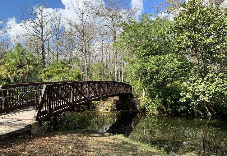 Eine Brücke führt die Besucher über den See im Orchid Park.