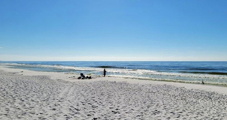 Pescador y un garza en Princess Beach