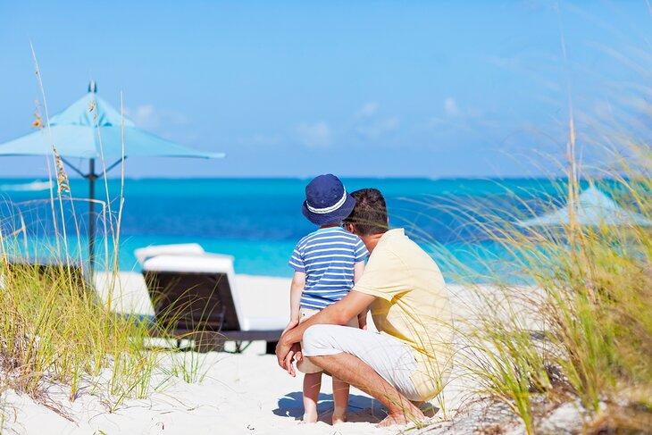 Padre e hijo disfrutando de la hermosa playa en los Turcos y Caicos