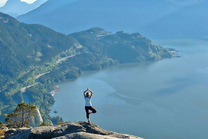 Wanderer macht Yoga auf dem Gipfel des The Chief