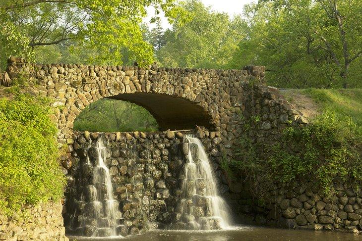 Puente de piedra y cascada en los Jardines Reynolda en Winston-Salem