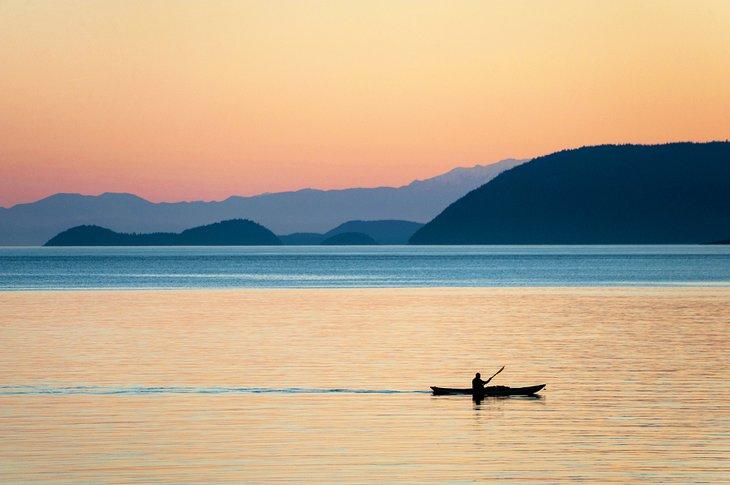 Kayakista pasando junto a la Isla Orcas al atardecer