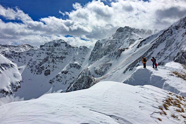 Snowboarders vérifiant le terrain expert à Silverton Mountain